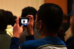 地元のスター選手を写真に収めるファン