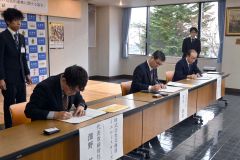 協定書に署名する（左から）澤野社長、田中町長、山岸教育長