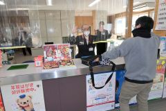 強盗役の警察官と相対する局員ら