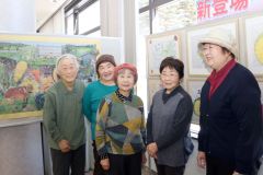 季節を感じられる作品を展示している会員（中央が石田代表）