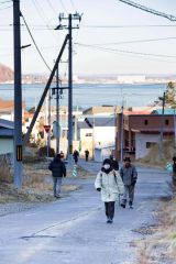 津波に備えた訓練で、自宅から高台の安全な場所まで徒歩で避難する音調津地区の住民ら(13日午前9時過ぎ、広尾町音調津、石原秀樹通信員撮影)