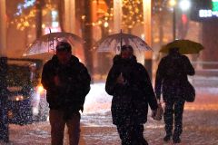 降り続く雪に傘を差しながら歩く住民(14日午後6時ごろ、帯広駅北口で。塩原真撮影)