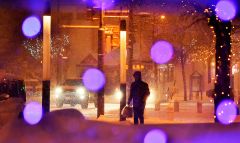 イルミネーションがともった12月の中心街で雪が降る中歩く住民(14日午後6時ごろ、帯広駅北口で。塩原真撮影