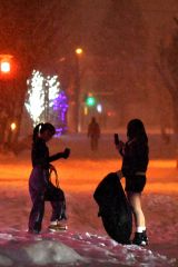 雪景色をスマホで撮影する歩行者(14日午後5時40分、帯広駅南口で)