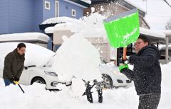 降り積もった雪を除雪をする市民(15日午前7時20分ごろ、帯広市新町西8で。塩原真撮影)