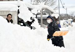 降り積もった雪を除雪をする市民(15日午前7時20分ごろ、帯広市新町西8で。塩原真撮影)