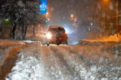 帯広市内の道道幕別帯広芽室線で立ち往生した車を押す人(15日午前1時20分ごろ、西8南28。貞野真生撮影)