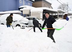 降り積もった雪を除雪をする市民(15日午前7時20分ごろ、帯広市新町西8で。塩原真撮影)