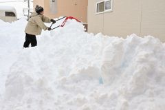 早朝から自宅前の除雪に追われる市民(15日午前7時半ごろ、帯広市内の清流地区で。金野和彦撮影)