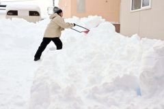 早朝から自宅前の除雪に追われる市民(15日午前7時半ごろ、帯広市内の清流地区で。金野和彦撮影)