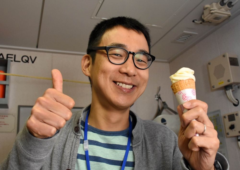 ソフトクリームを片手にポーズをとる同行者の須藤健司さん